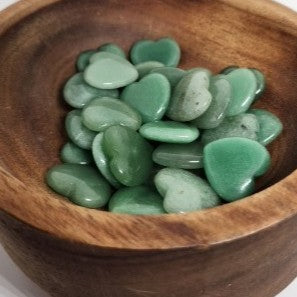 Green heart-shaped stones in a wooden bowl