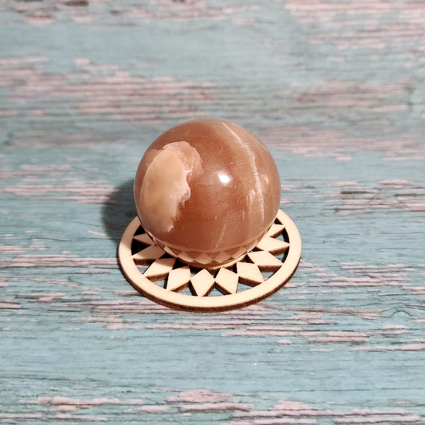 Decorative doorknob with a brown spherical design on a textured blue door