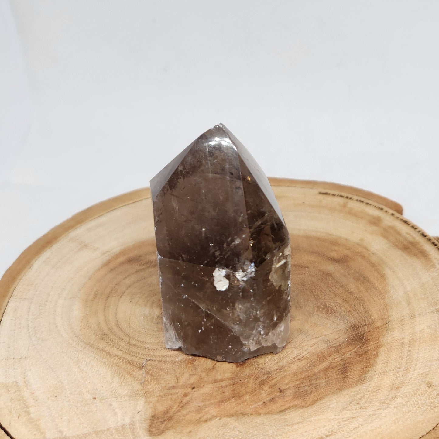 Smoky crystal on a wooden stand against a white background