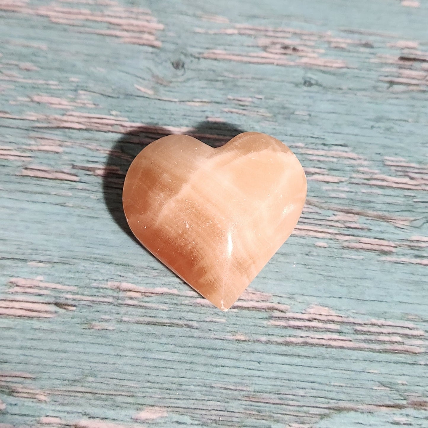 Heart-shaped stone on a textured blue surface