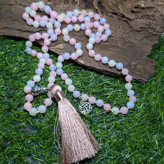 Necklace with pink beads and tassel on a wooden and grass background