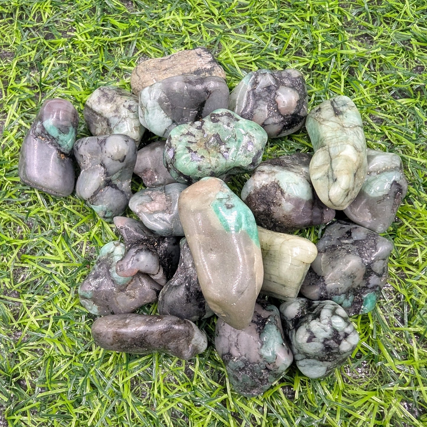 Collection of green and gray stones on grass