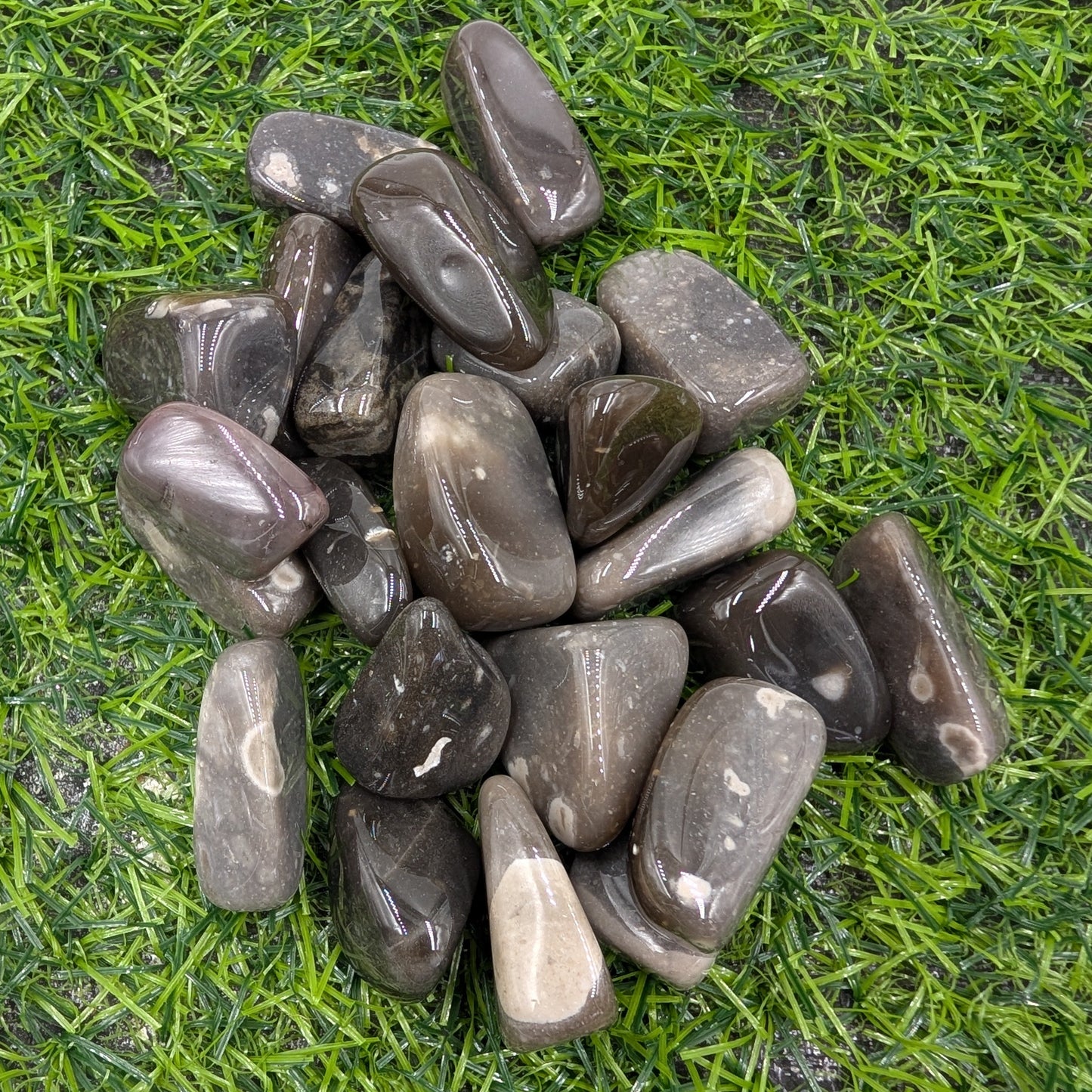 Pile of dark gray stones on green grass