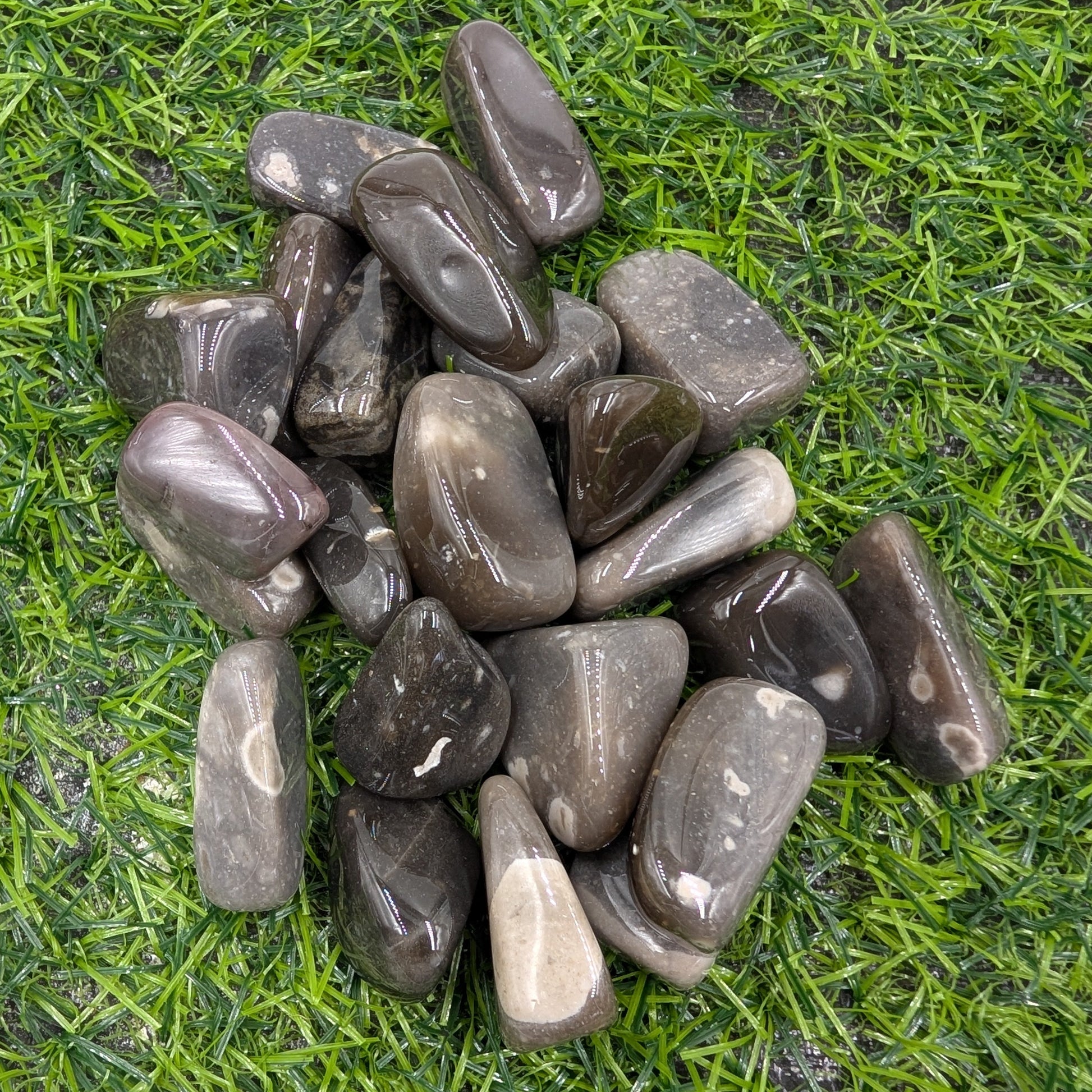 Pile of dark gray stones on green grass