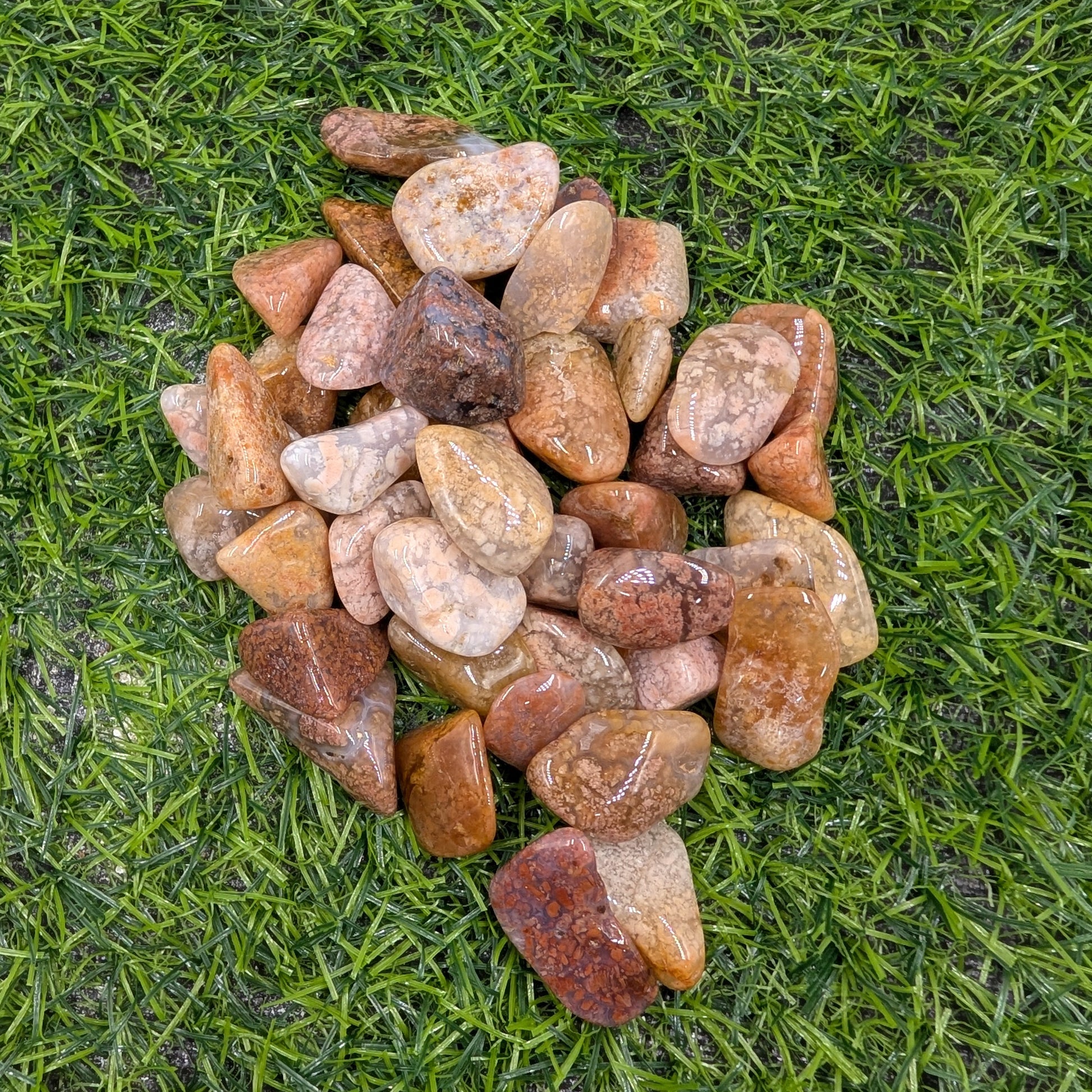 Pile of multicolored stones on green grass