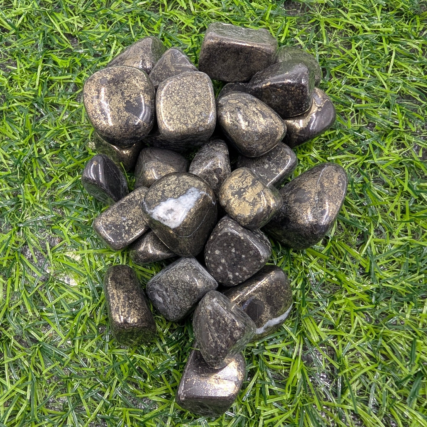 Pile of dark stones on a grassy surface