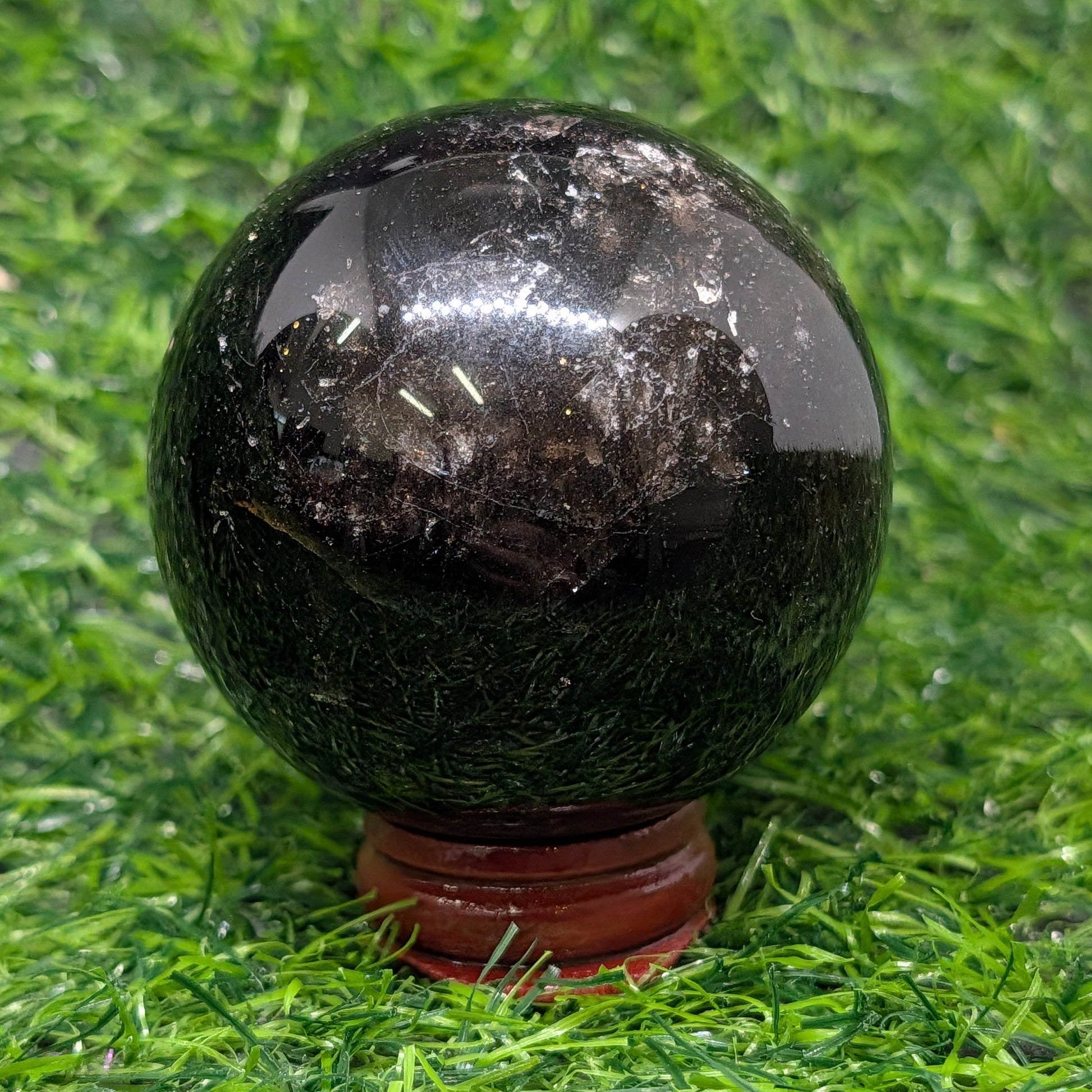 Black crystal sphere on a grassy background