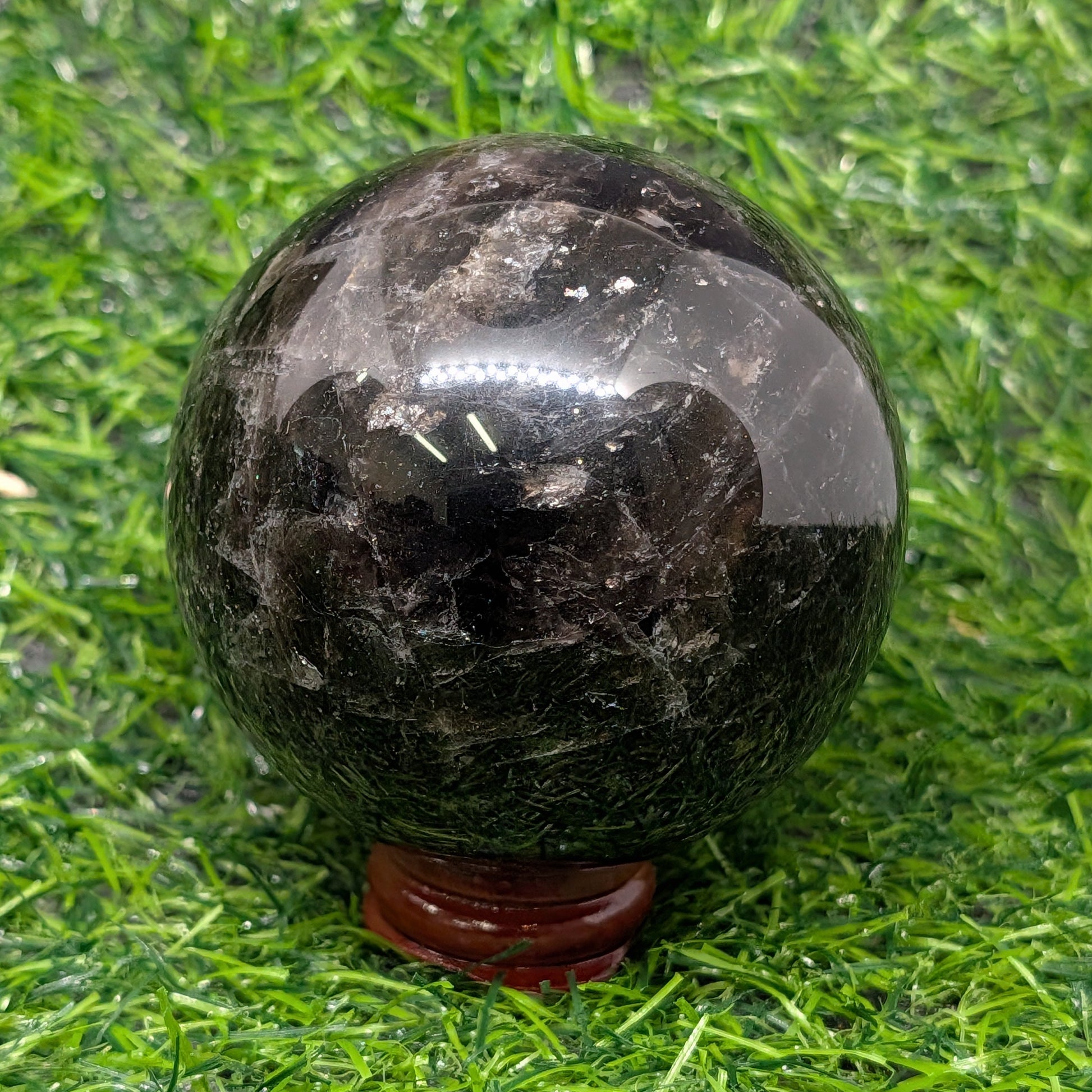 Black stone sphere on a grassy background