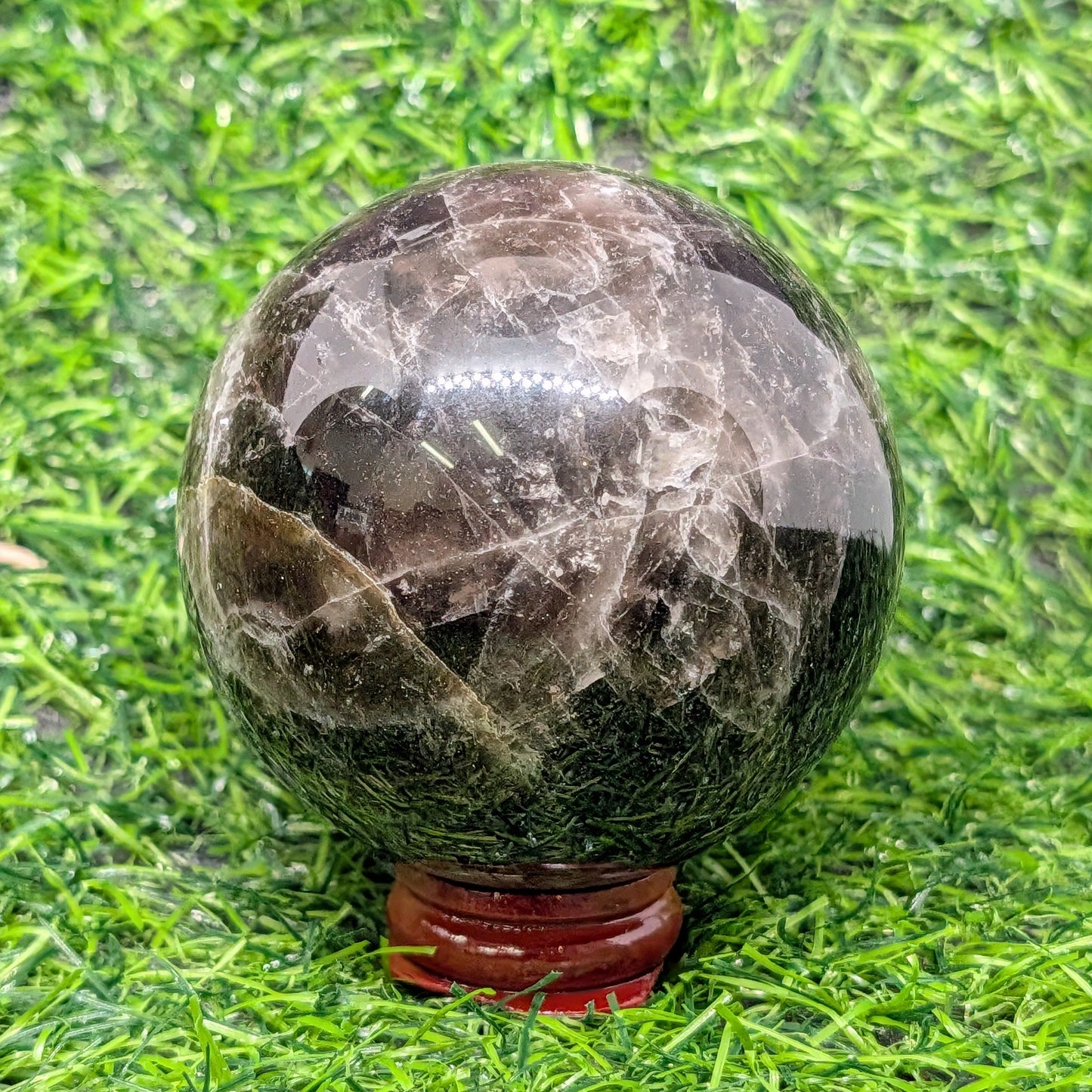 Marble-like sphere on a stand with grass background