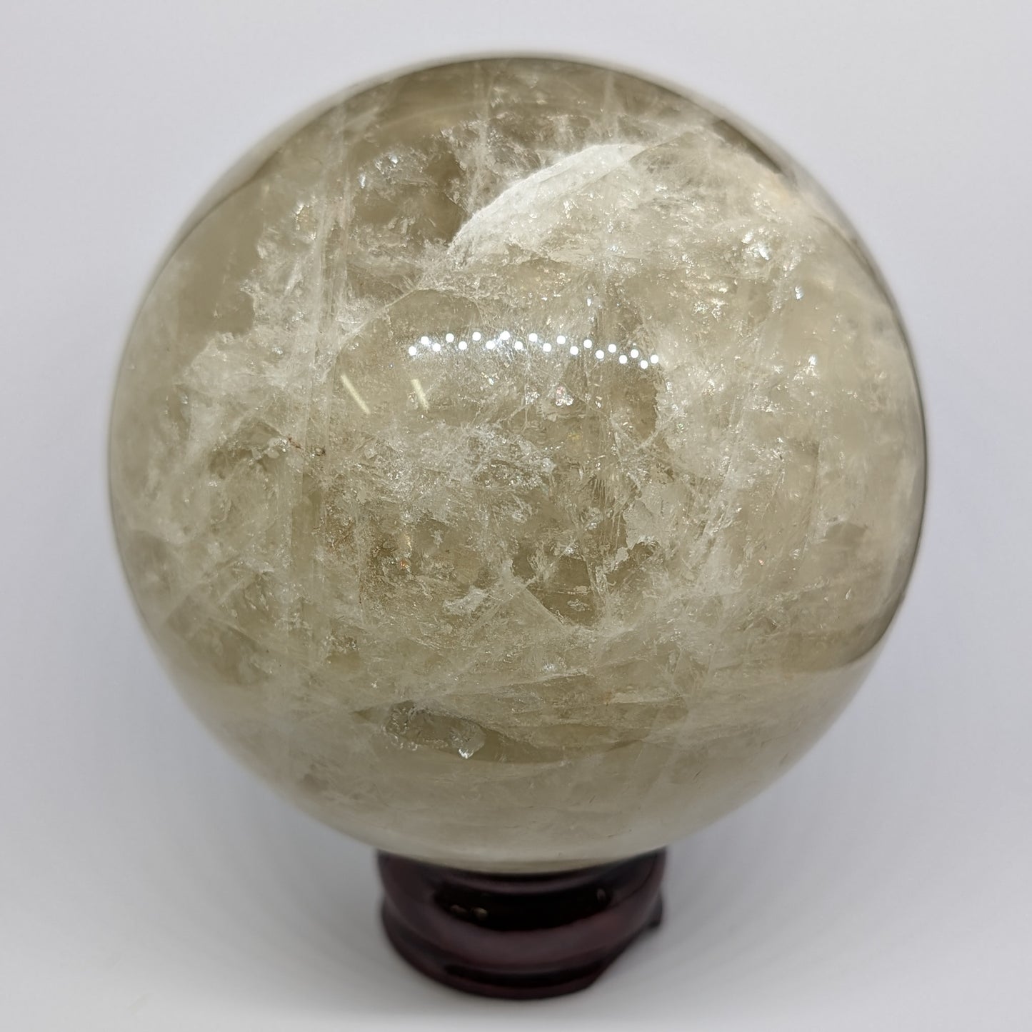 Crystal ball with a wooden stand on a white background