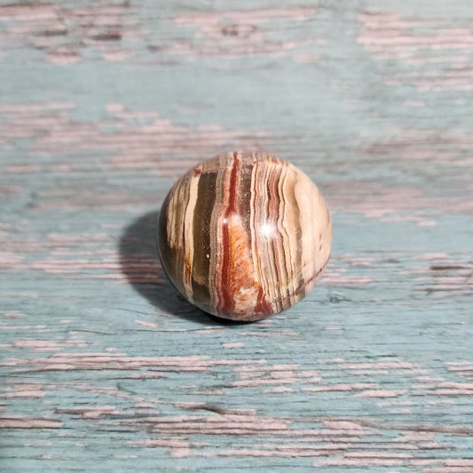 Round stone with striped pattern on a textured blue surface