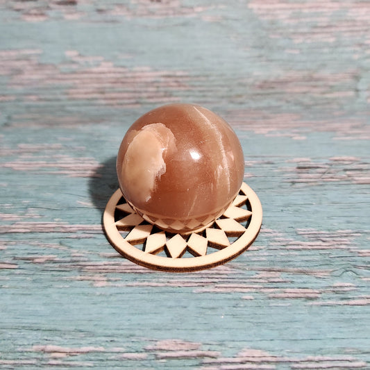 Decorative doorknob with a brown spherical design on a textured blue door