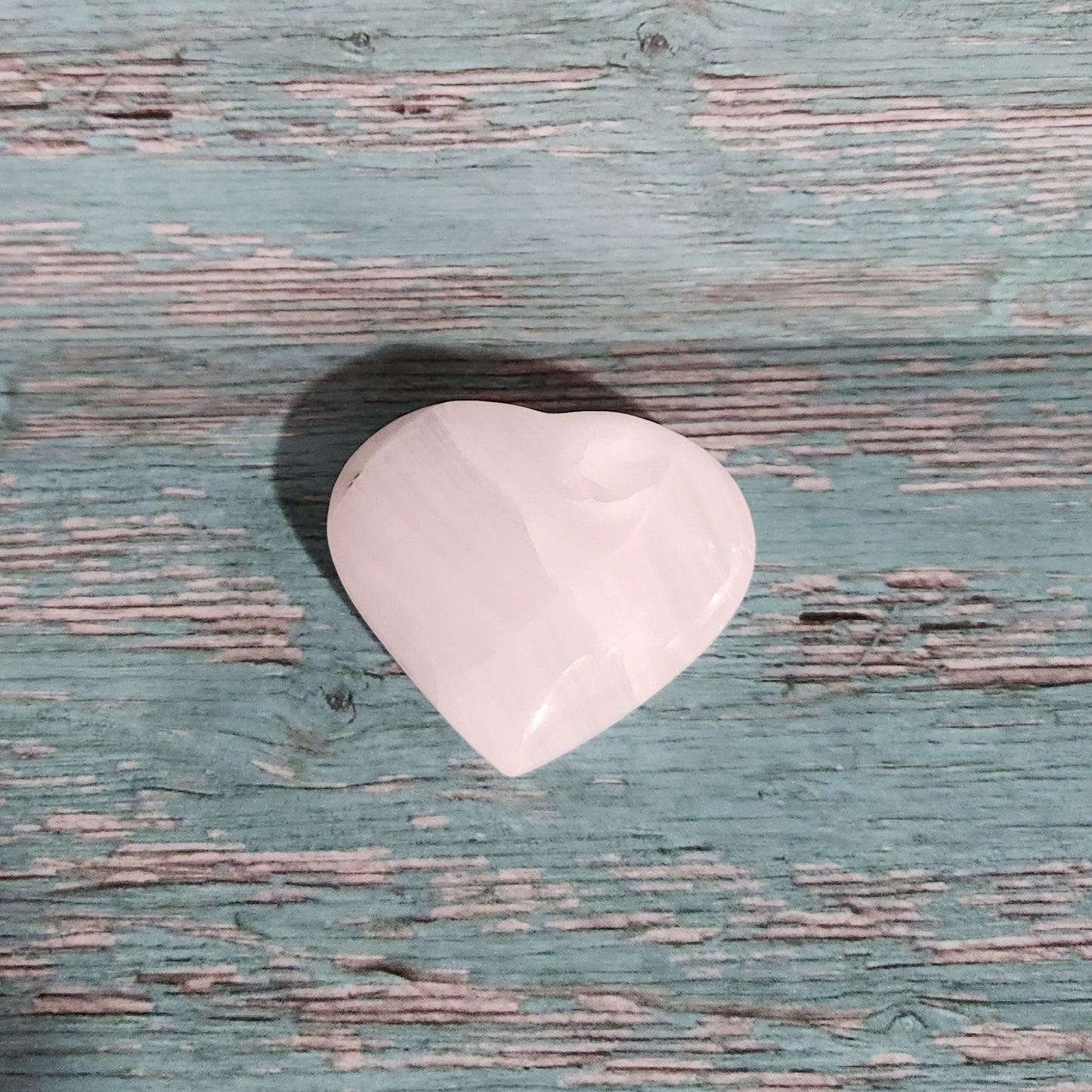 White guitar pick on a textured blue surface