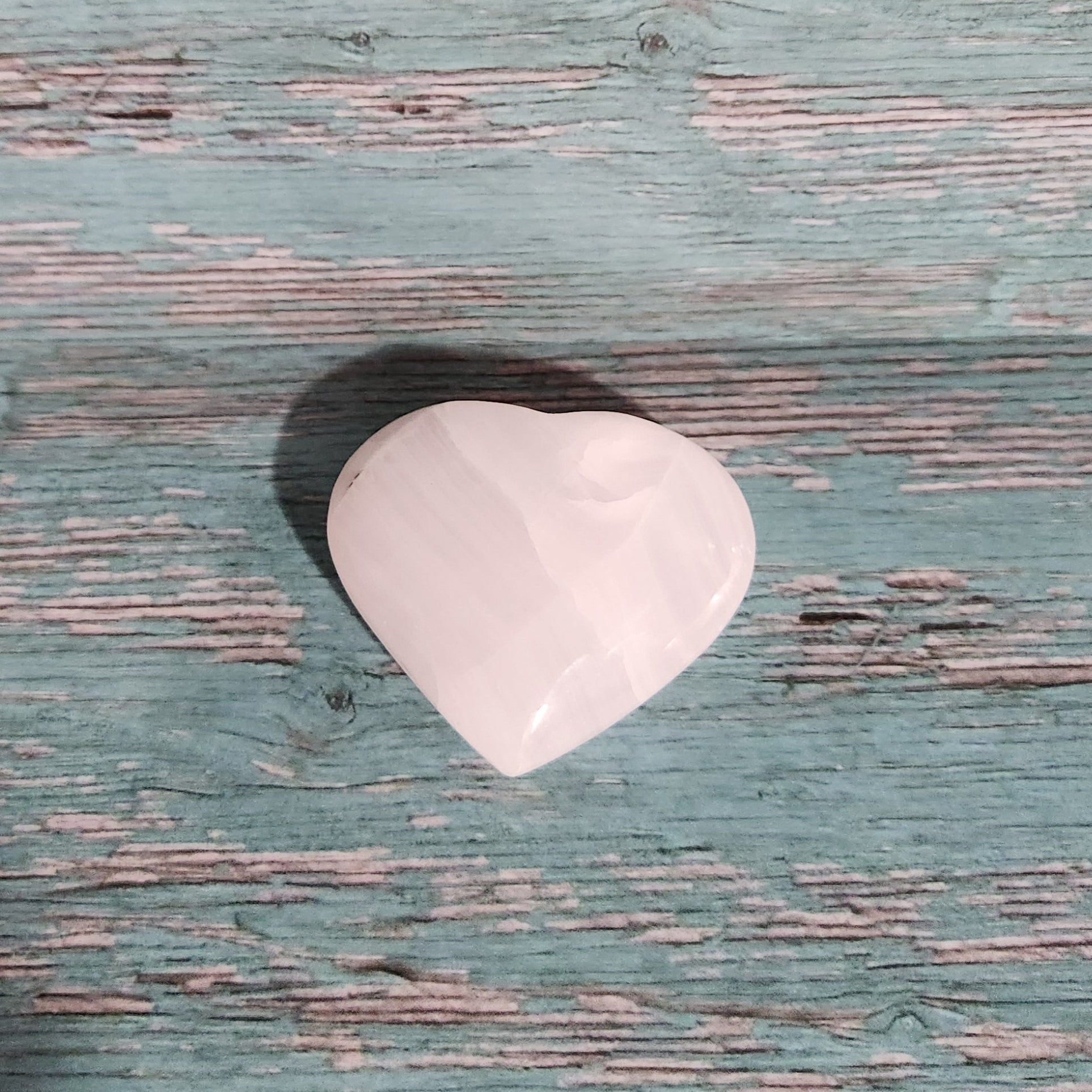 White guitar pick on a textured blue surface