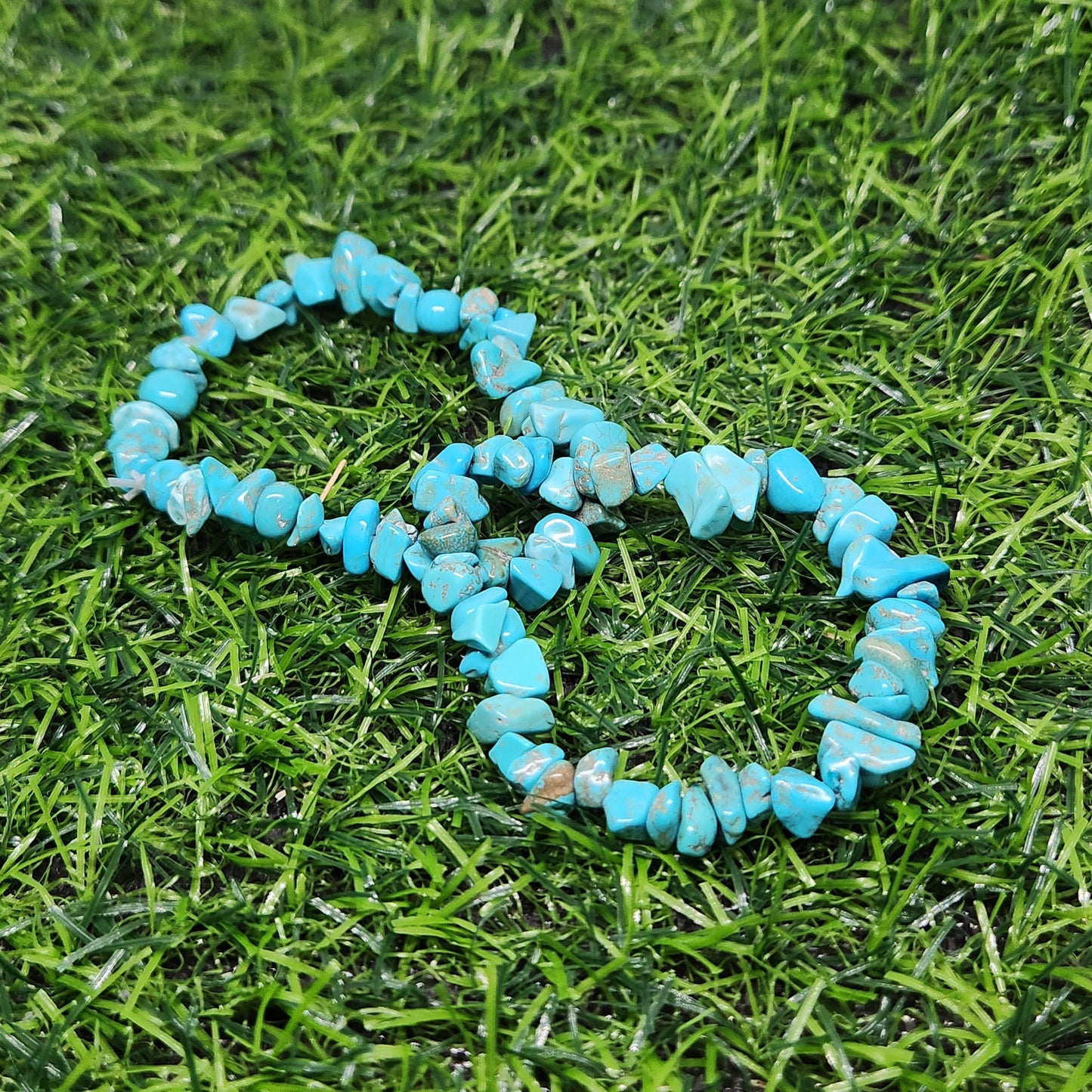 Turquoise beaded bracelet on a grassy surface