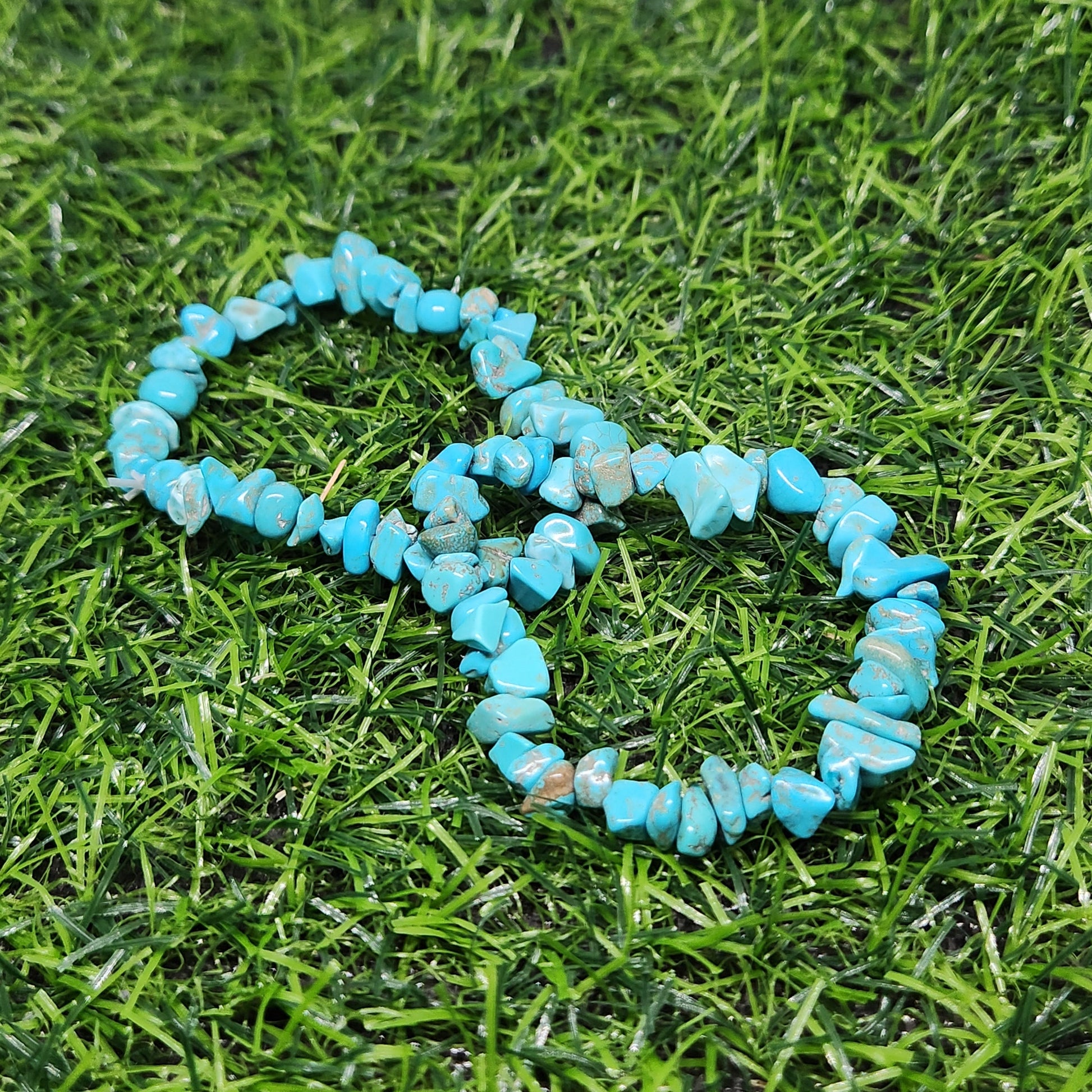 Turquoise beaded bracelet on a grassy surface