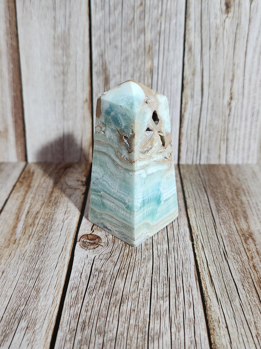 Polished amazonite crystal on a wooden surface
