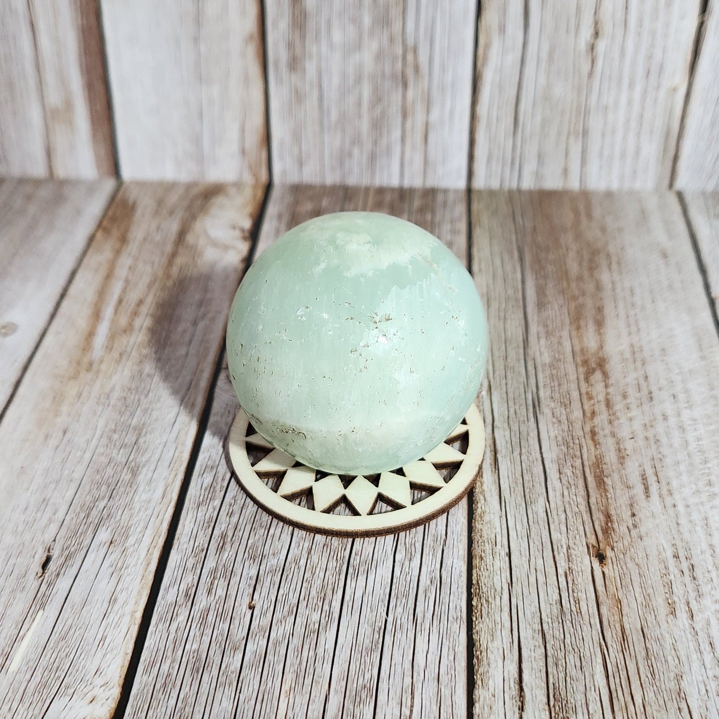 Light blue ball with a decorative pattern on a wooden surface