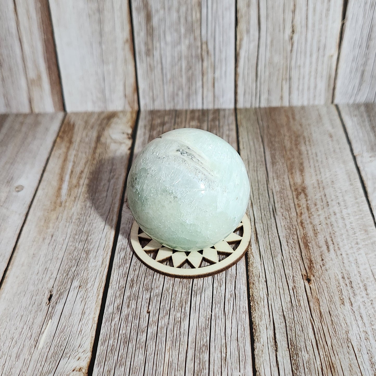 Decorative stone ball with a wooden base on a wooden wall