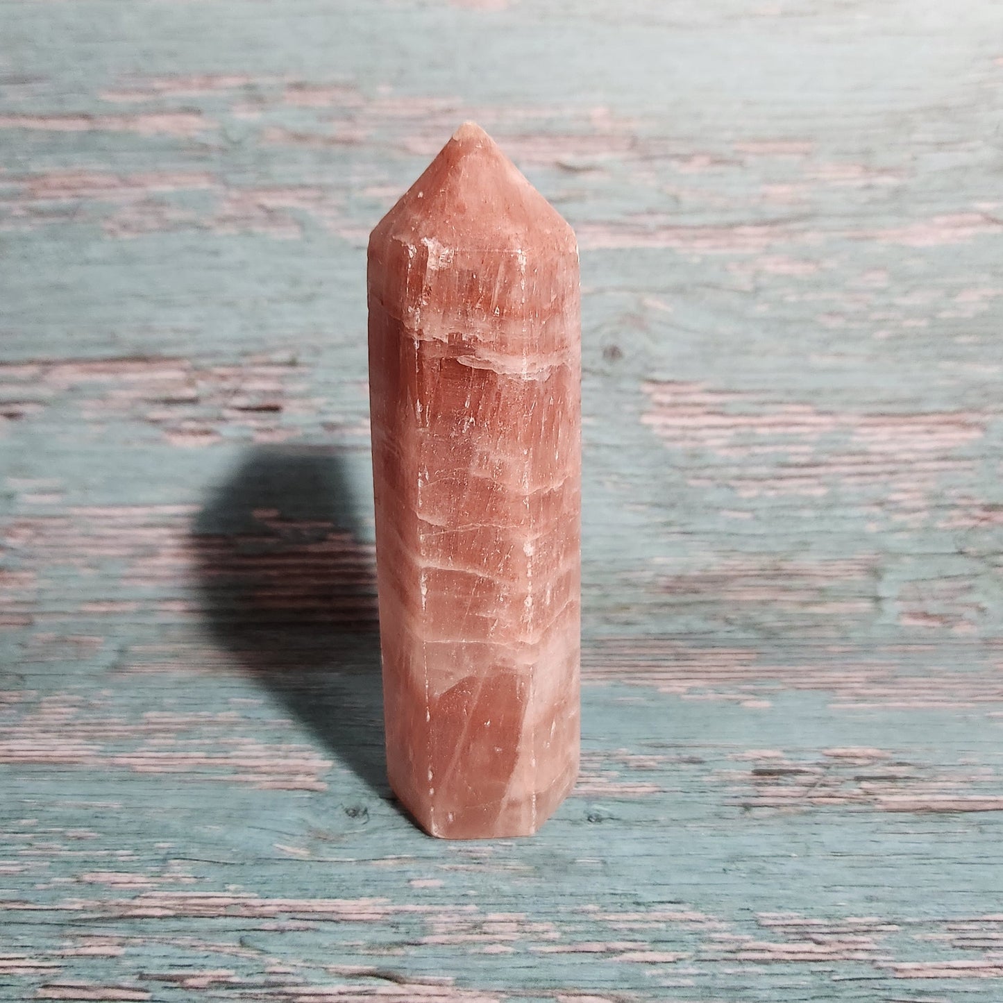 Rectangular pink crystal on a textured blue surface