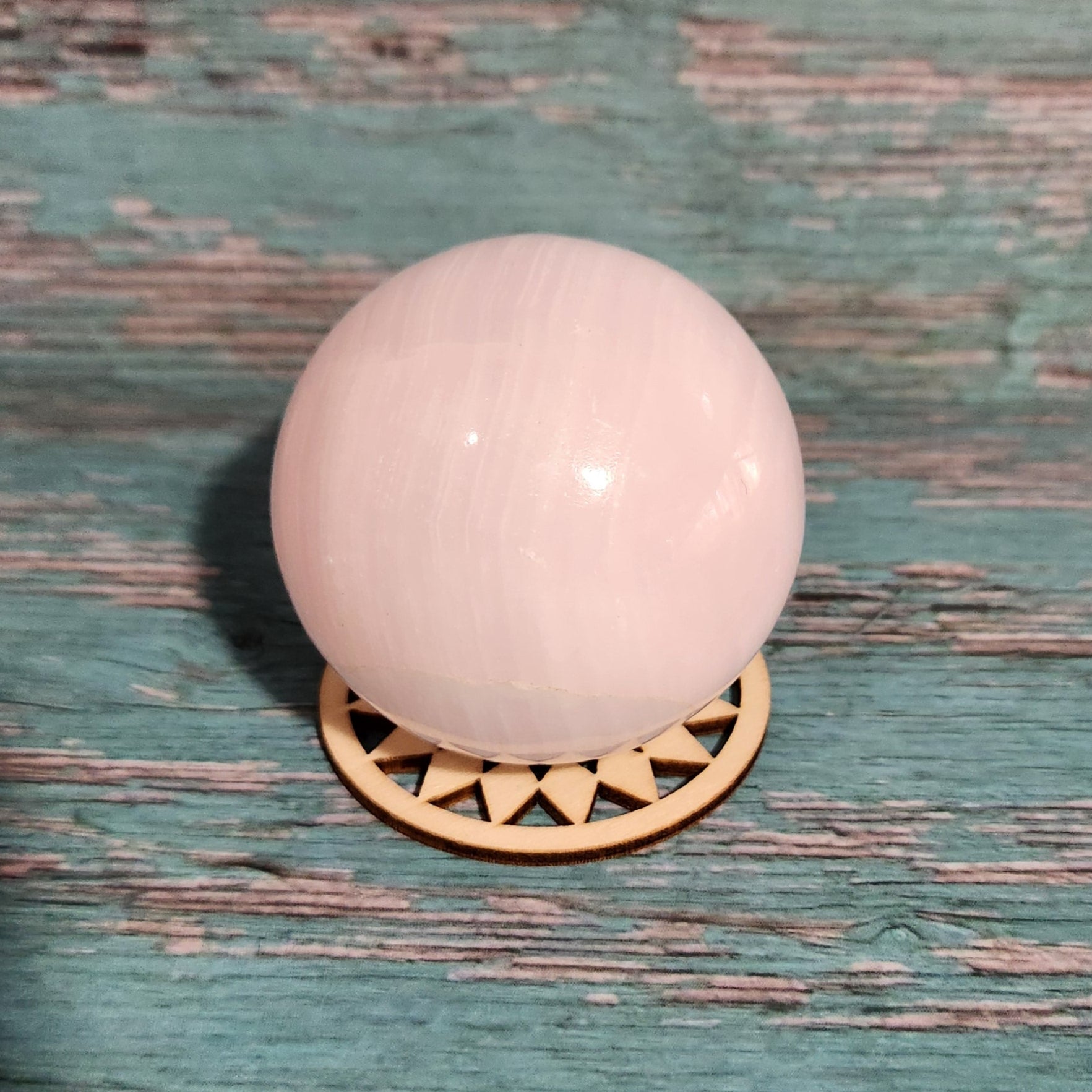 Pink light bulb on a textured green surface