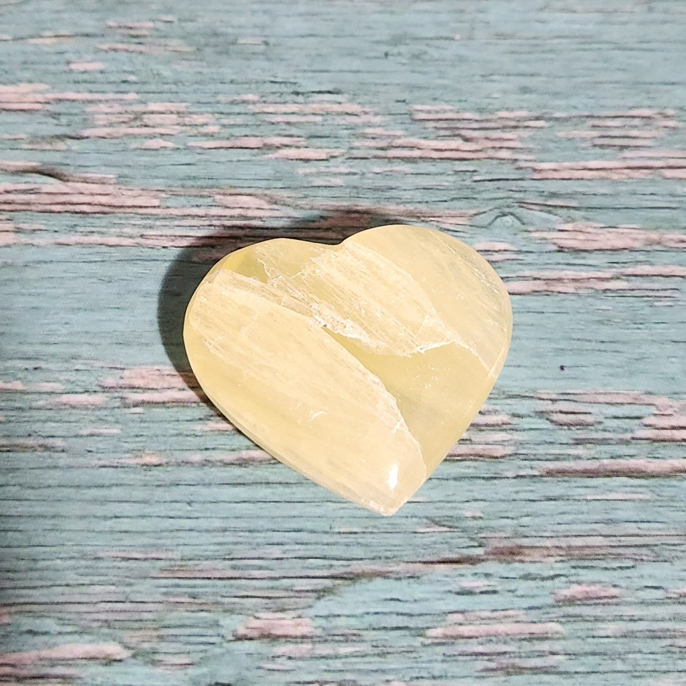 Heart-shaped gold object on a textured blue surface