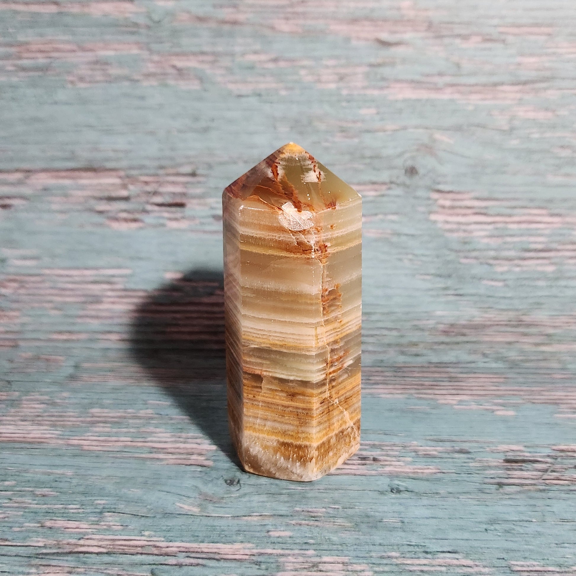 Polished stone crystal on a textured wooden surface
