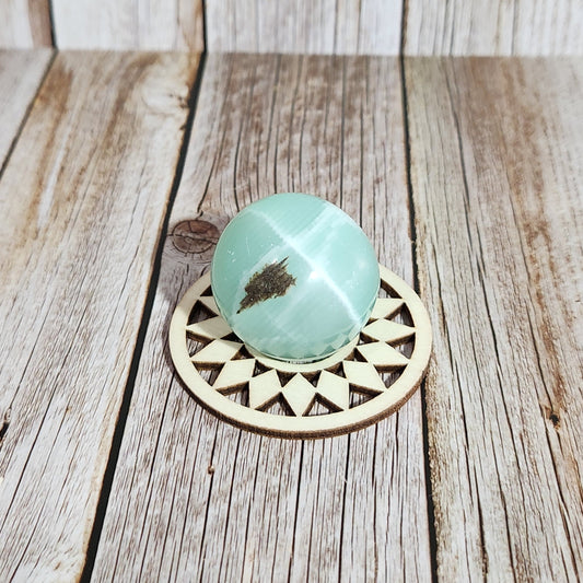 Decorative wooden knob with a turquoise stone on a wooden surface