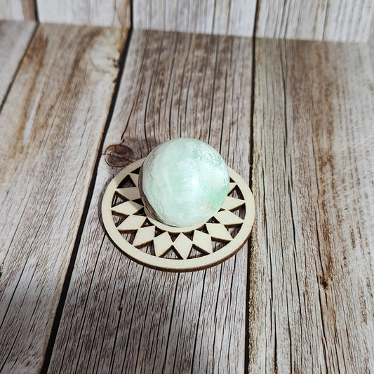 Decorative wooden knob with a green knob on a wooden surface