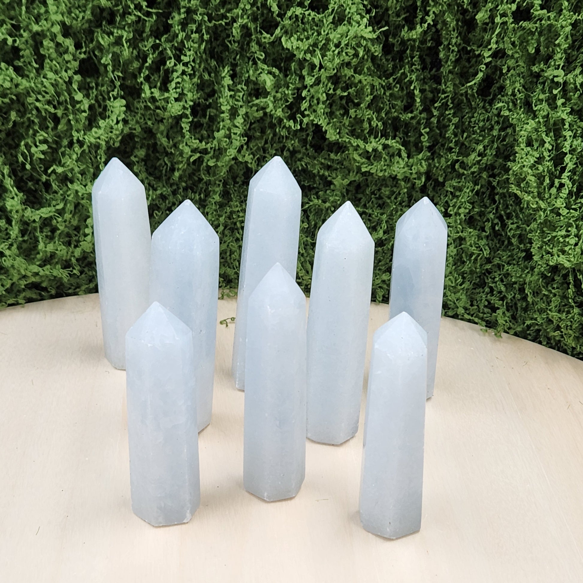 Set of crystal points against a green bush and white background