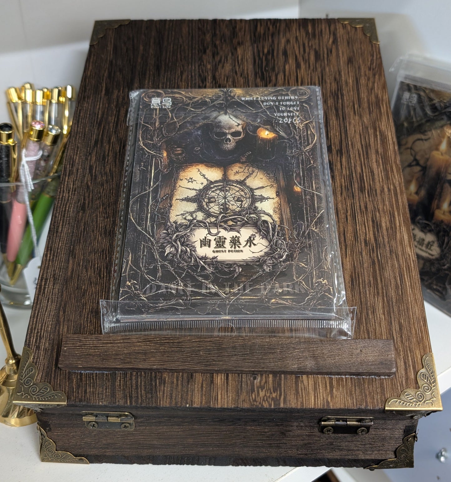 Wooden box with a transparent lid displaying a design, on a white surface.