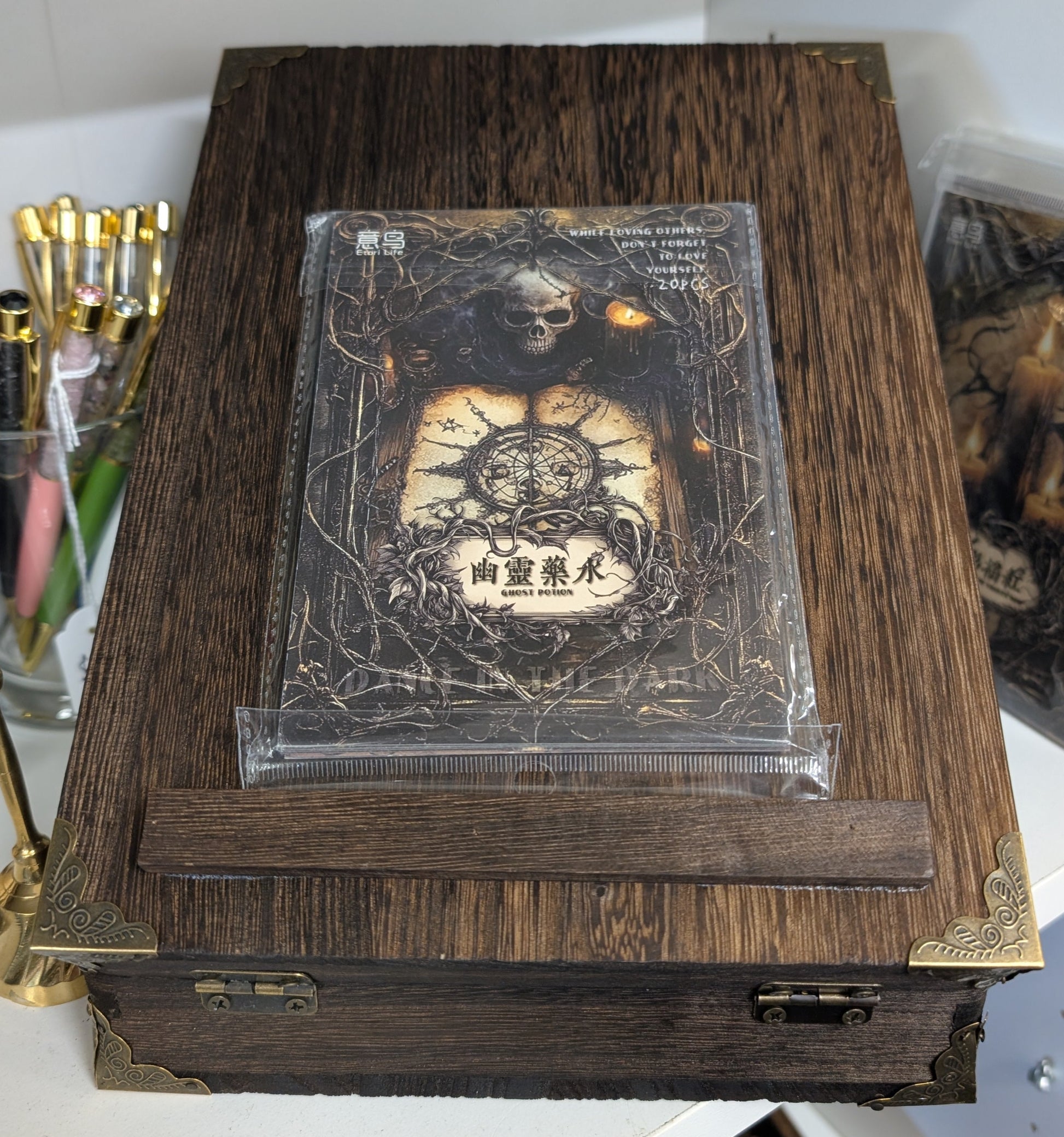 Wooden box with a transparent lid displaying a design, on a white surface.