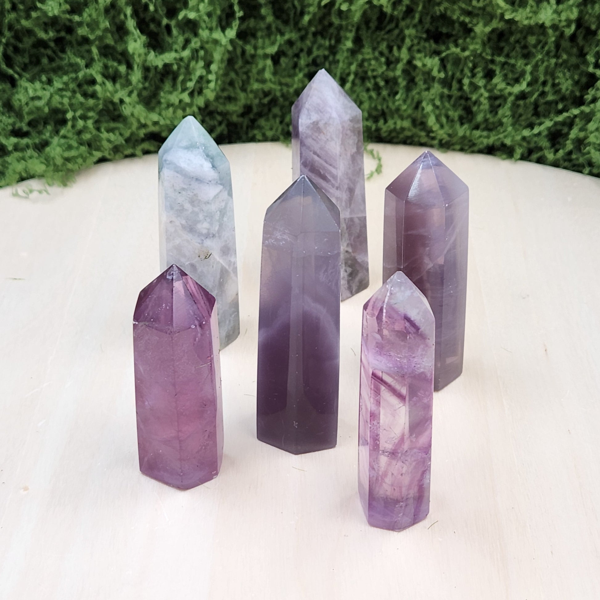 Set of crystal points on a white surface with greenery in the background