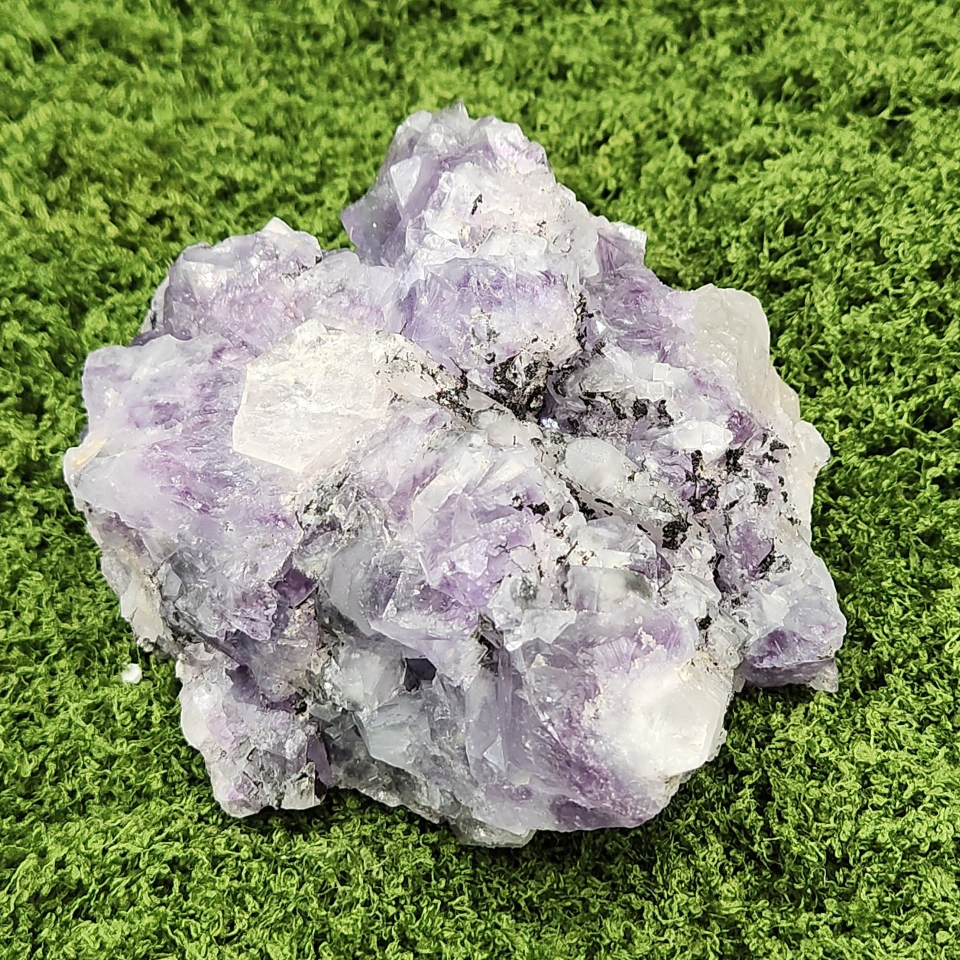 Purple crystal cluster on a green moss background