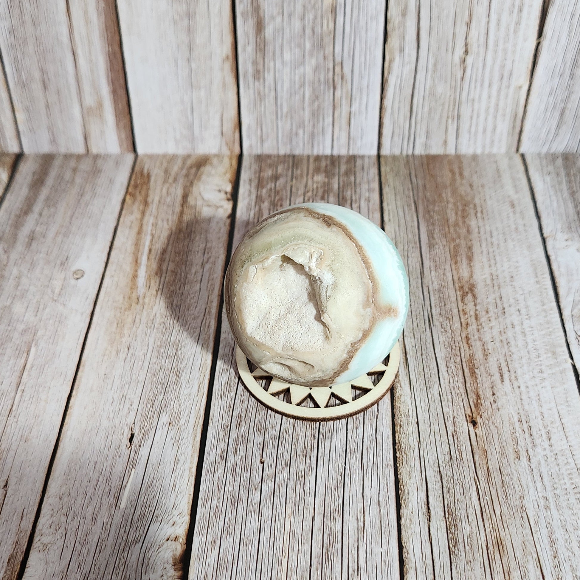 Decorative stone with circular design on a wooden surface