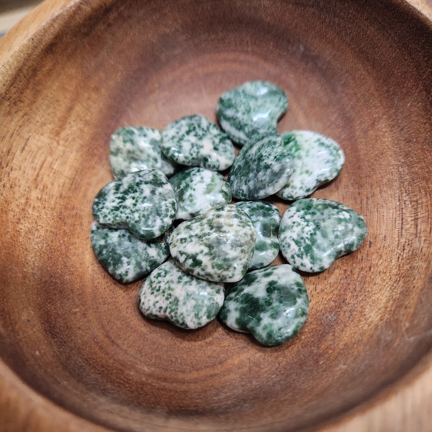 Green stones on a wooden plate